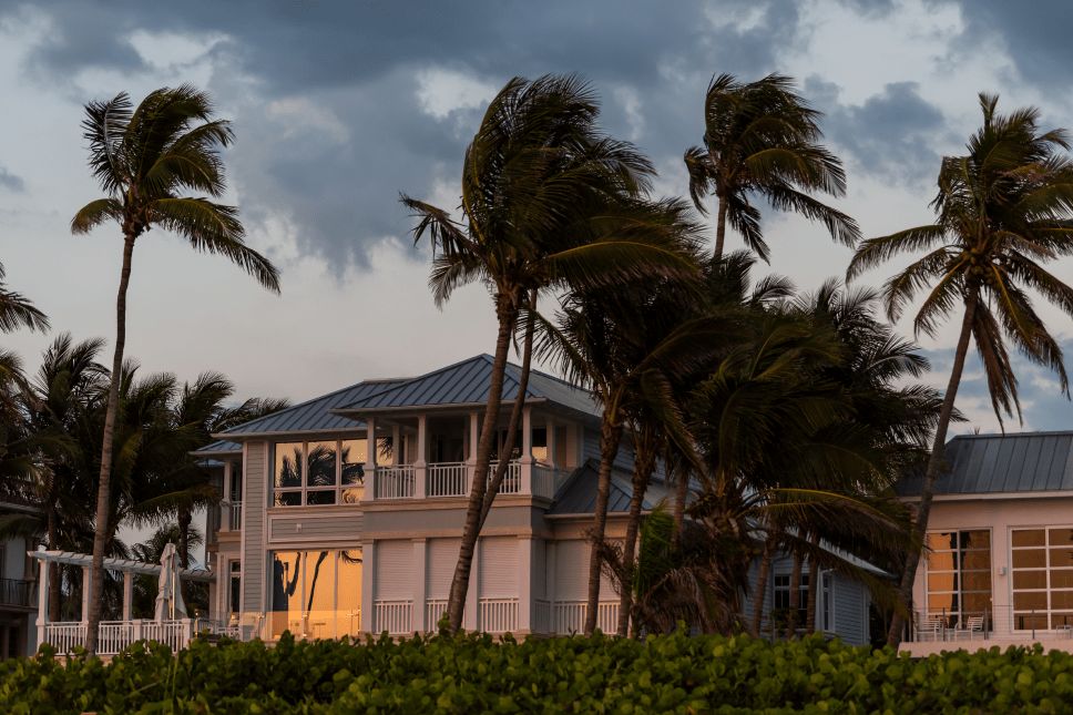 Home in the middle of a hurricane with trees leaning due to strong winds.