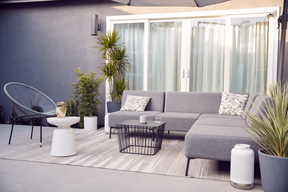 A spacious back patio with an outdoor furniture set and greenery to enhance the home’s curb appeal.