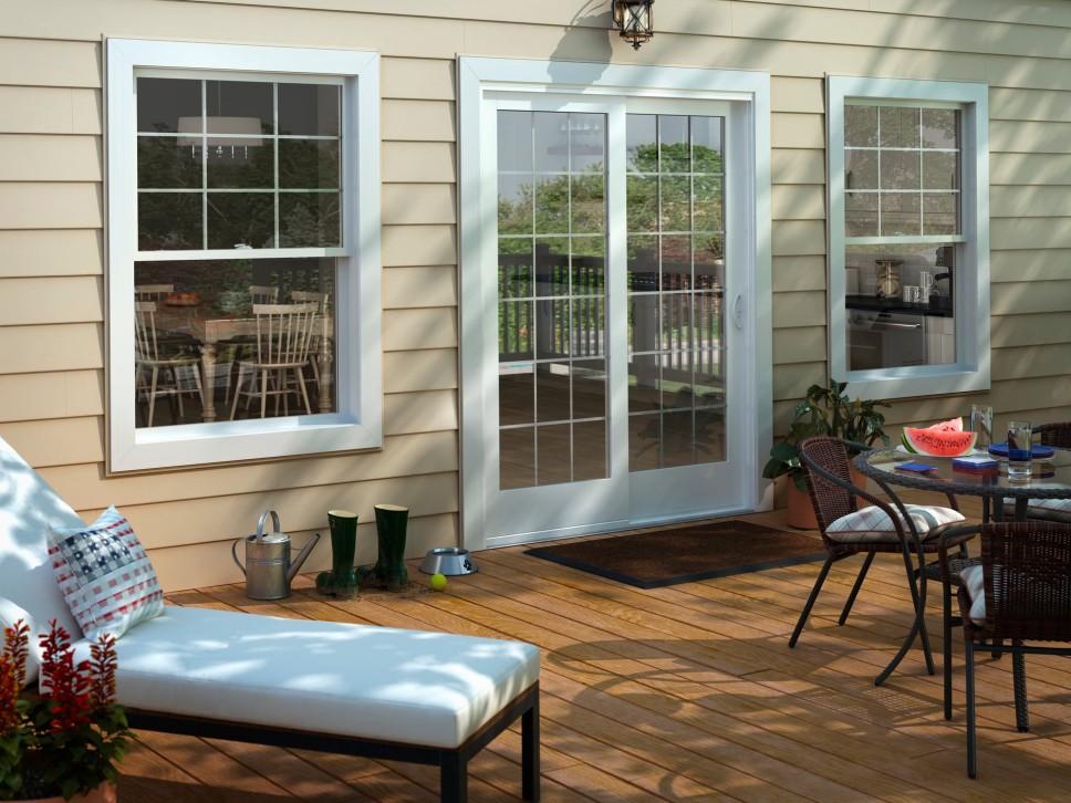 Sliding patio door and outside patio with a table with a watermelon on top of it and chairs surround